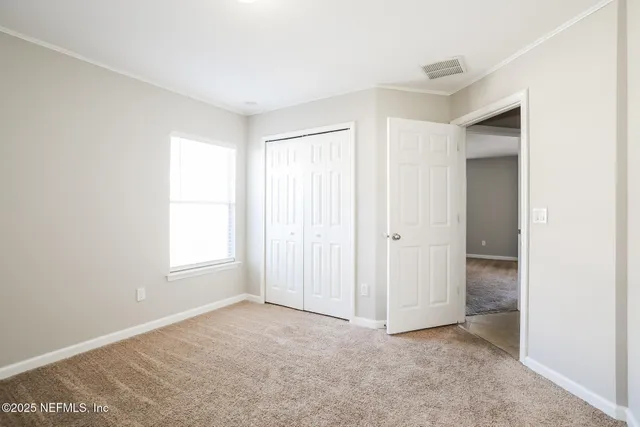 an empty room with windows and closet