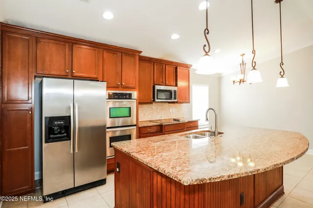 a kitchen with kitchen island a counter top space appliances and a counter top space