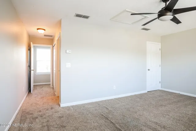 a view of hallway with a chandelier fan