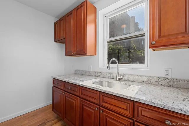 a sink with wooden floor and cabinets
