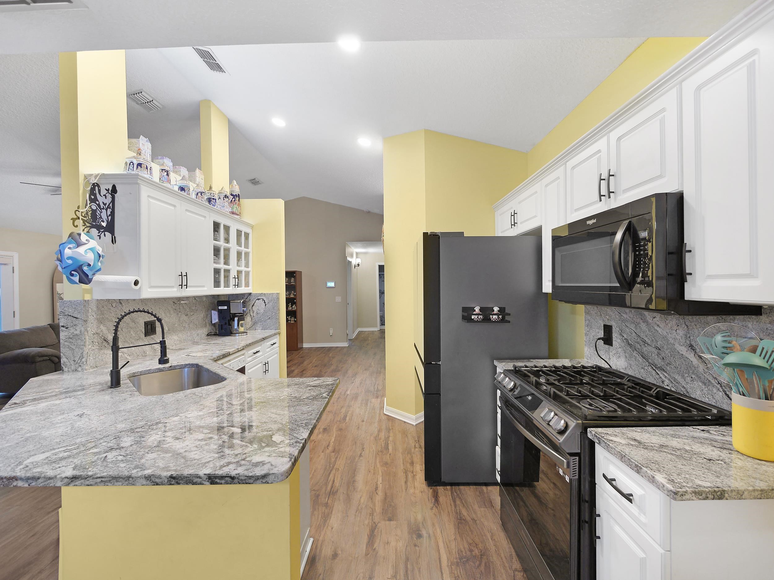 549 Willow Walk Place St. Augustine, FL 32086 - Photo 7 of 32 a kitchen with stainless steel appliances granite countertop a sink stove and refrigerator