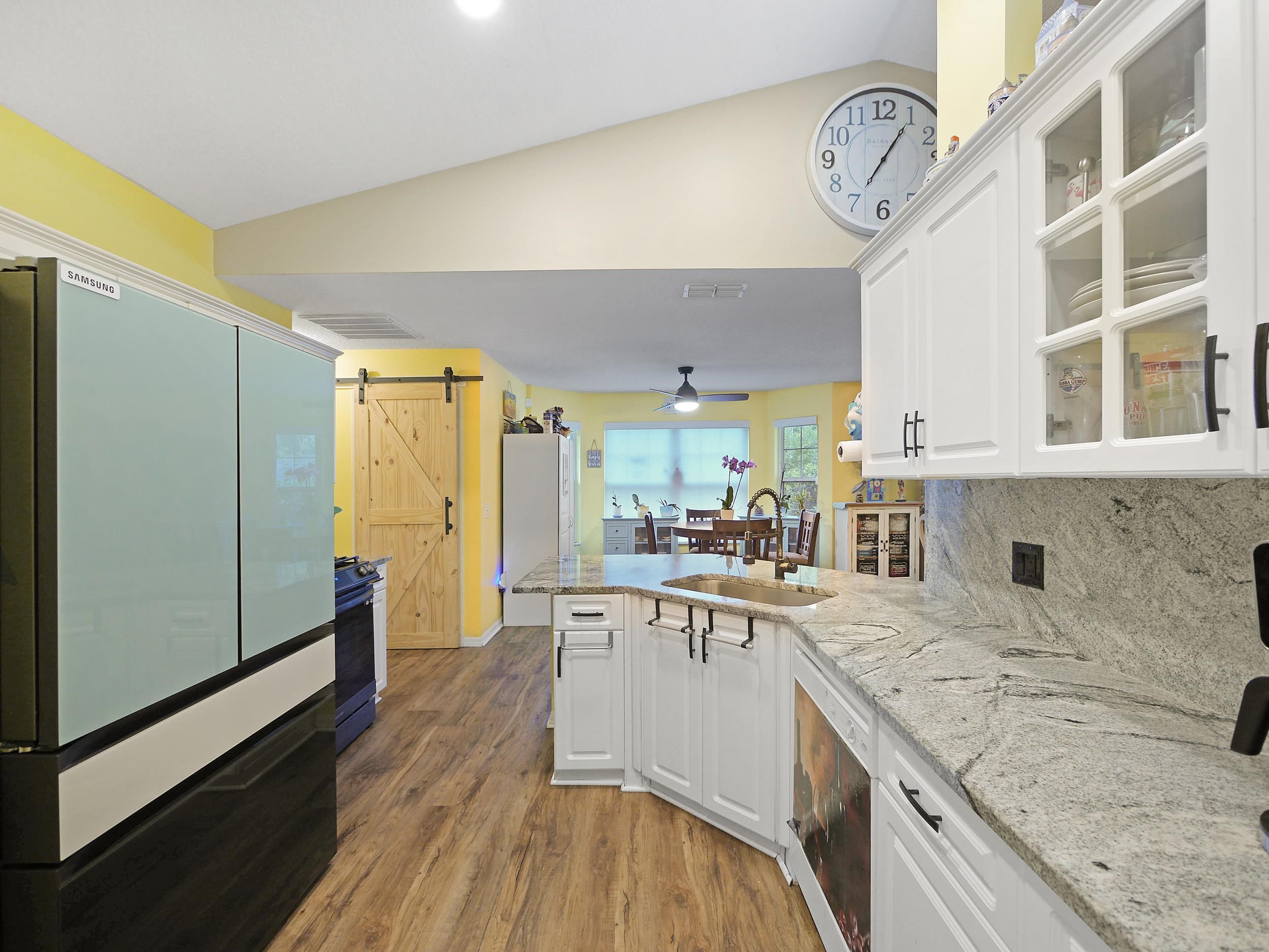 549 Willow Walk Place St. Augustine, FL 32086 - Photo 8 of 32 a large kitchen with a lot of counter space and a wooden floor