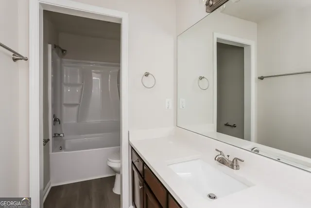 a bathroom with a tub sink and mirror