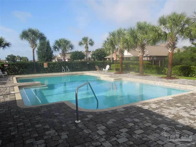 an aerial view of a house with swimming pool and large trees