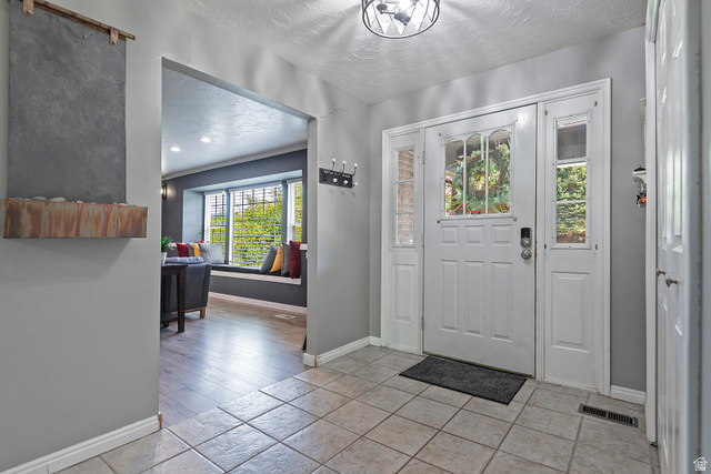 3310 Creek Road Salt Lake City, UT 84121 - Photo 36 of 49 Entryway featuring ceramic tile flooring, a white paneled front door with decorative glass, and sidelight windows