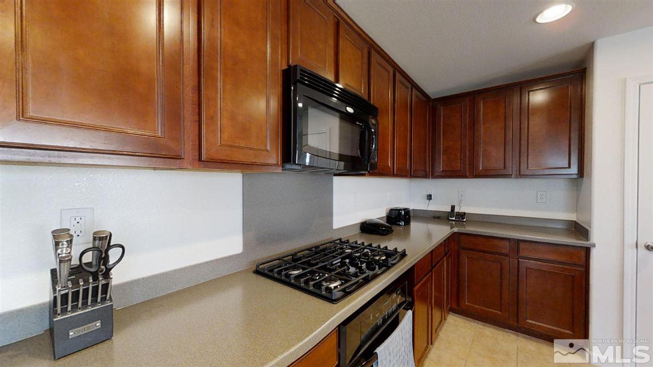 335 Teramo Drive Reno, NV 89521 - Photo 5 of 21 a kitchen with granite countertop a stove top oven microwave and cabinets