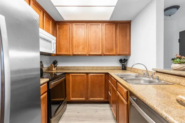 a kitchen with stainless steel appliances granite countertop a sink stove and refrigerator