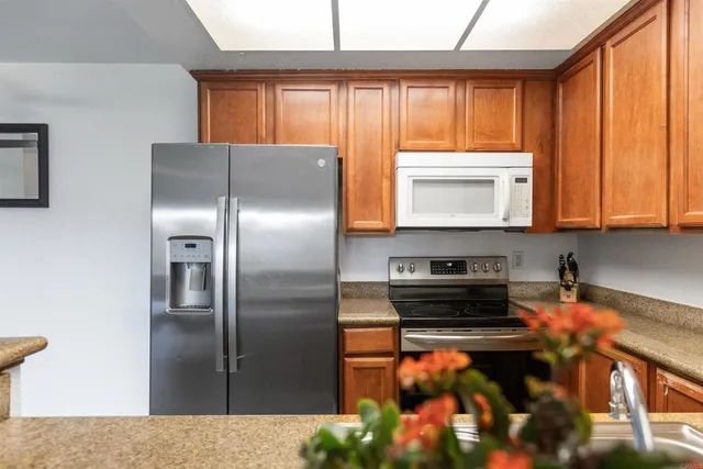 a kitchen with stainless steel appliances granite countertop a refrigerator and a stove