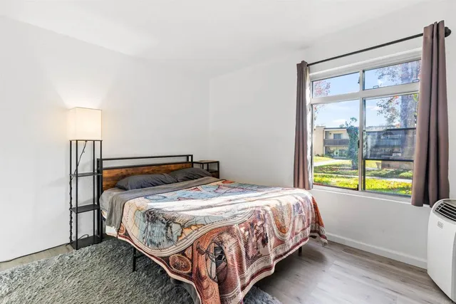 a bedroom with a bed and a lamp next to a window