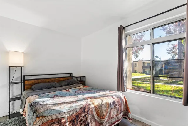 a bedroom with a bed and a large window