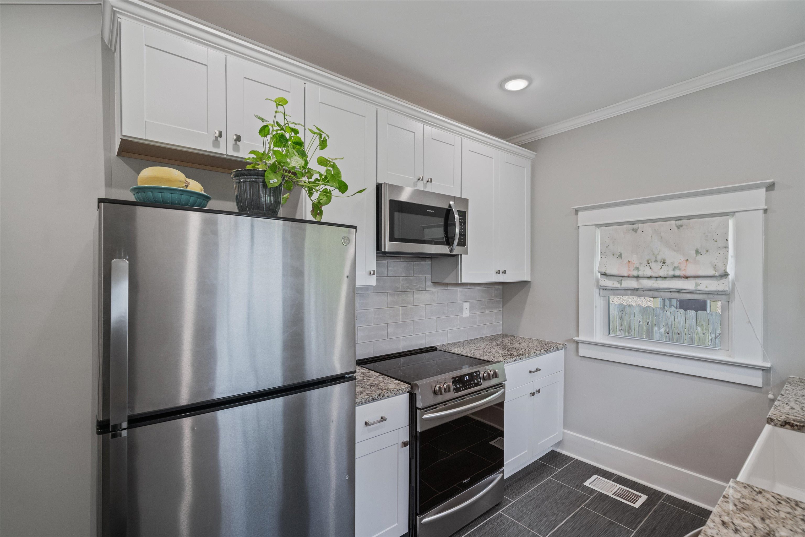 1893 Felix Avenue Memphis, TN 38114 - Photo 8 of 25 a kitchen with stainless steel appliances granite countertop a refrigerator a sink a stove a microwave a sink and cabinets