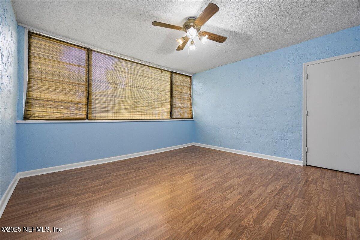 2628 Southwest 14th Drive, Unit 326 Gainesville, FL 32608 - Photo 11 of 17 a view of an empty room with a window and wooden floor