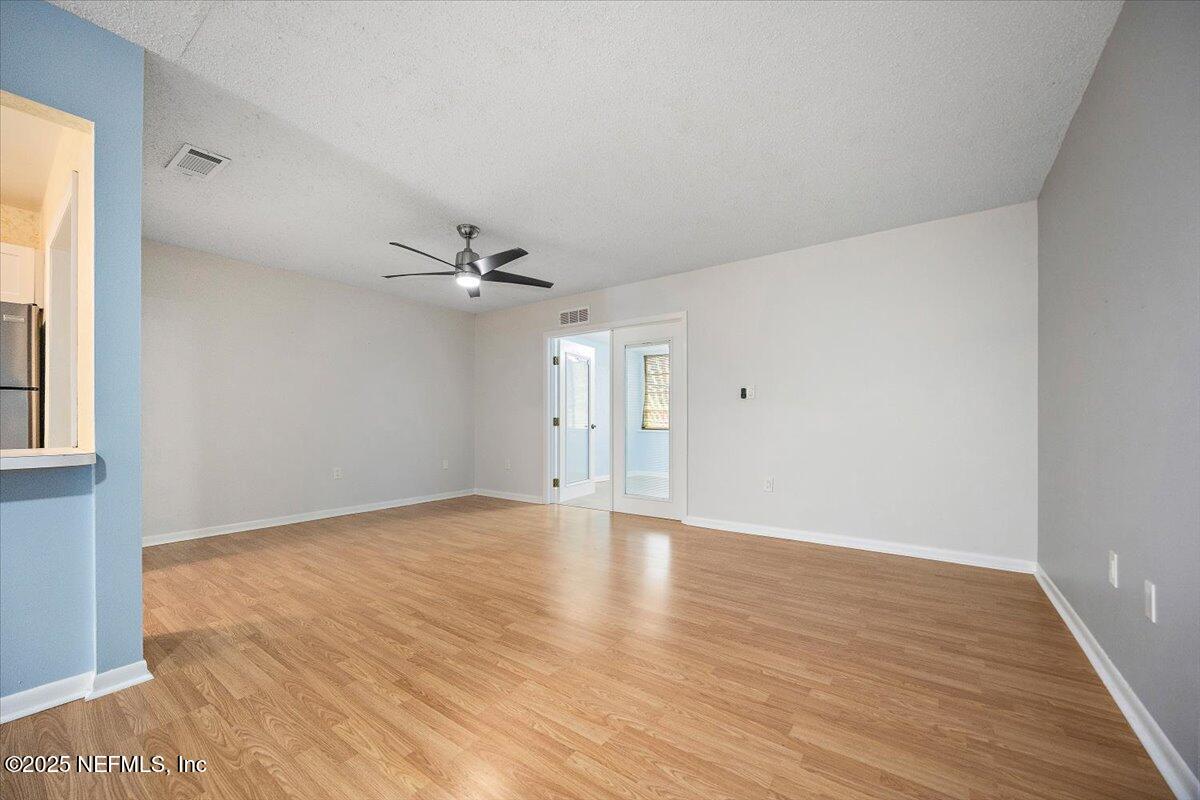 2628 Southwest 14th Drive, Unit 326 Gainesville, FL 32608 - Photo 2 of 17 a view of an empty room with wooden floor and a window