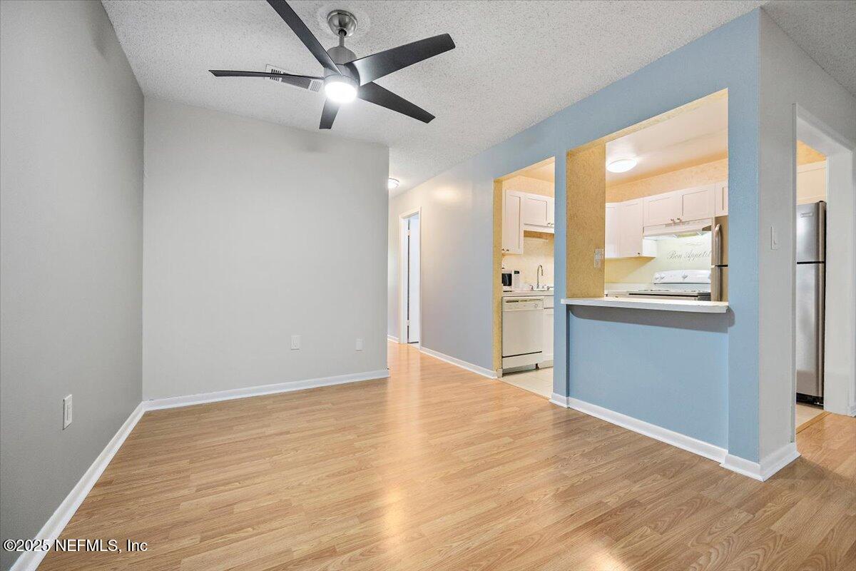 2628 Southwest 14th Drive, Unit 326 Gainesville, FL 32608 - Photo 5 of 17 a view of an empty room with wooden floor and a window