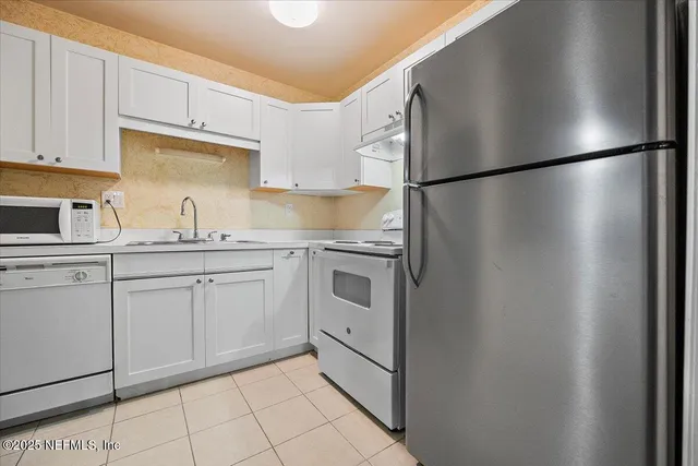 a kitchen with stainless steel appliances a refrigerator sink and cabinets