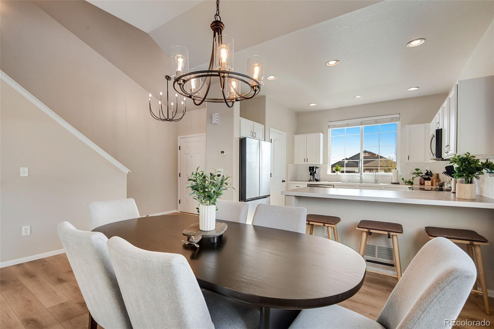 7035 McClellan Road Wellington, CO 80549 - Photo 9 of 43 a kitchen with stainless steel appliances a dining table chairs chandelier and living room view