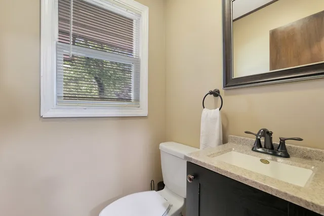a bathroom with a granite countertop sink toilet and a mirror