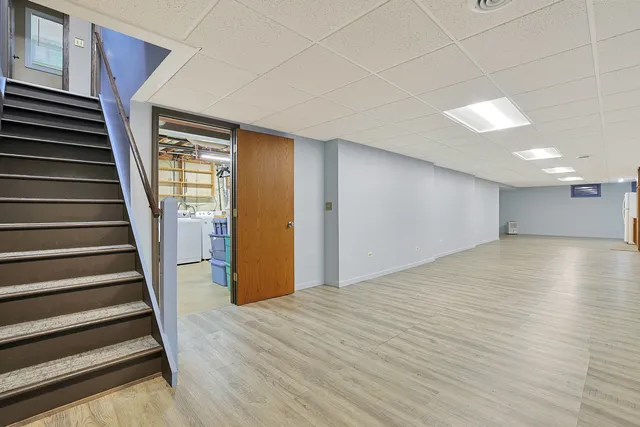 a view of a hallway with wooden floor and stairs