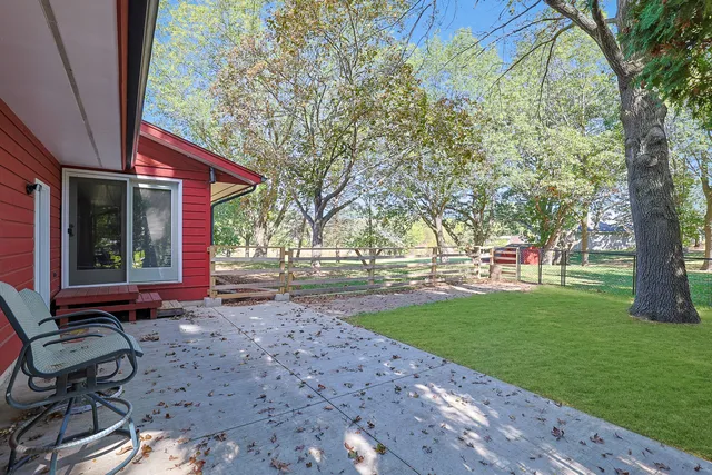 a view of a backyard with table and chairs and a barbeque with wooden fence