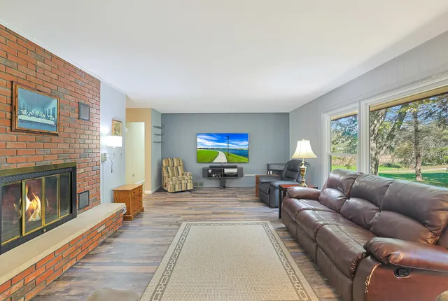 a living room with furniture a fireplace and a large window