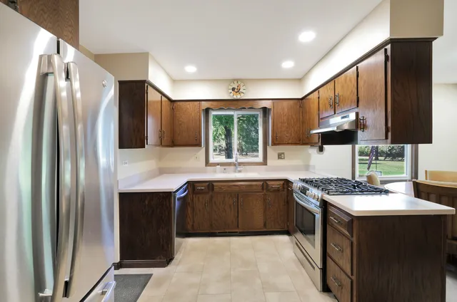 a kitchen with stainless steel appliances granite countertop a sink stove and refrigerator