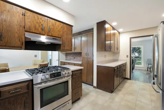a kitchen with stainless steel appliances a stove a sink and cabinets