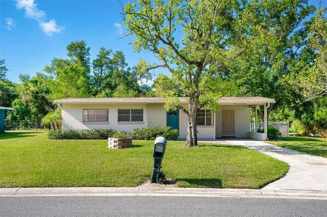 a front view of house with a garden and trees