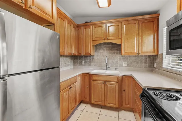 a kitchen with a refrigerator a sink and cabinets