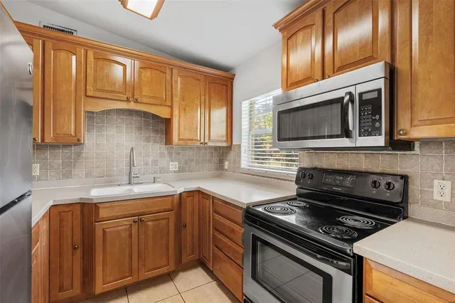 a kitchen with stainless steel appliances granite countertop a stove microwave and sink