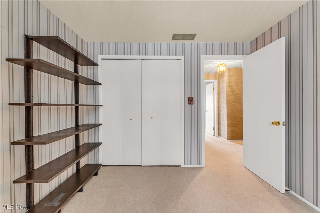 6470 State Road, Unit K5 Parma, OH 44134 - Photo 21 of 26 Unfurnished bedroom featuring light carpet, a closet, and wallpapered walls