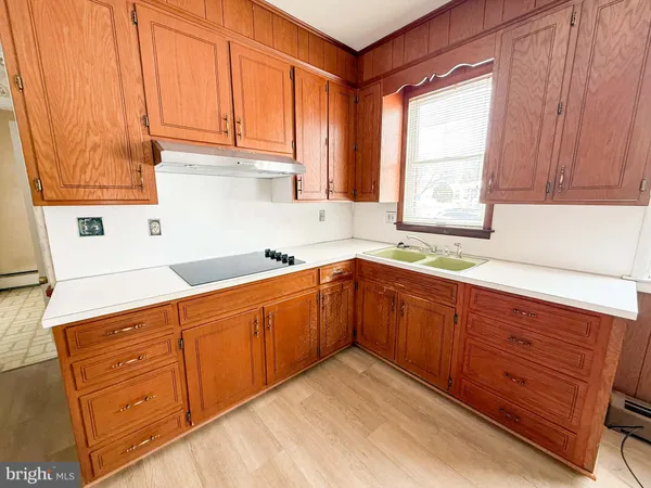 a kitchen with stainless steel appliances a refrigerator a sink a stove top oven a counter space and cabinets