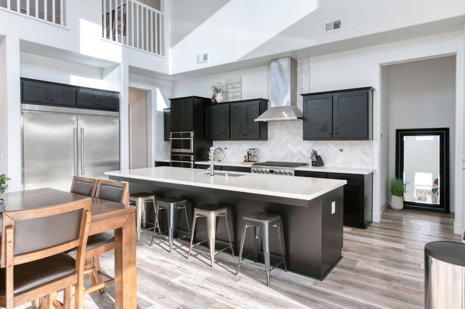 1736 North Renn Avenue Clovis, CA 93619 - Photo 14 of 66 a kitchen with stainless steel appliances kitchen island granite countertop a table chairs in it and wooden floors