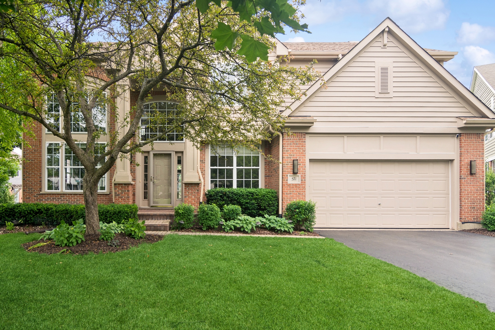 571 Quaker Ridge Court Vernon Hills, IL 60061 - Photo 1 of 17 a front view of a house with a garden and garage