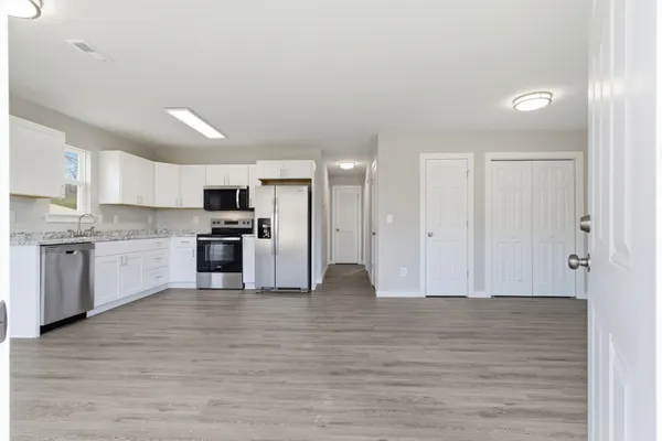 a kitchen with granite countertop a refrigerator and a stove top oven