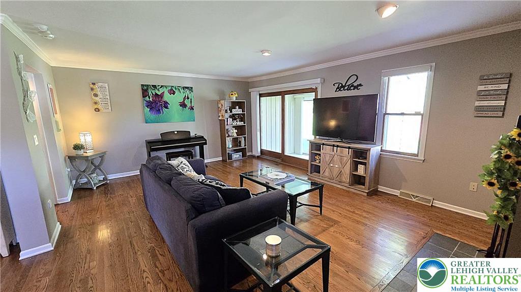 194 Springhouse Road Allentown, PA 18104 - Photo 7 of 34 This inviting living space features gleaming hardwood floors and ample natural light, creating a bright atmosphere.
