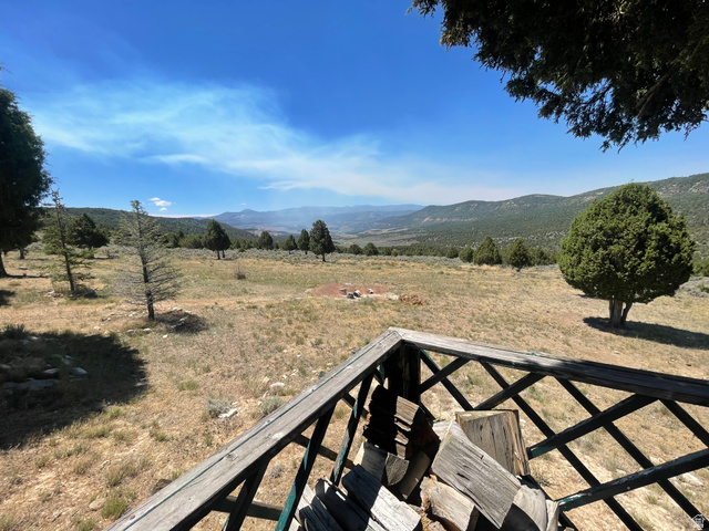 4648 West Taylor Flt Road Salina, UT 84654 - Photo 17 of 20 Expansive outdoor space featuring a wooden deck with lattice railing, mature trees, and distant mountain scenery