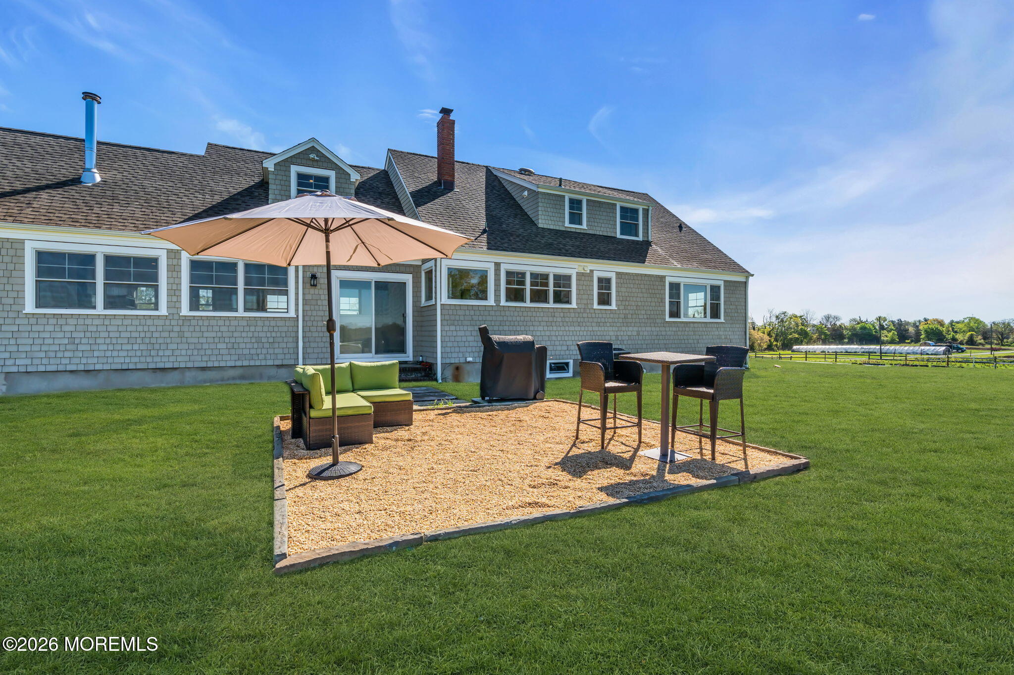 393 County Road 537 Colts Neck, NJ 07722 - Photo 20 of 41 a patio with a table and chairs under an umbrella