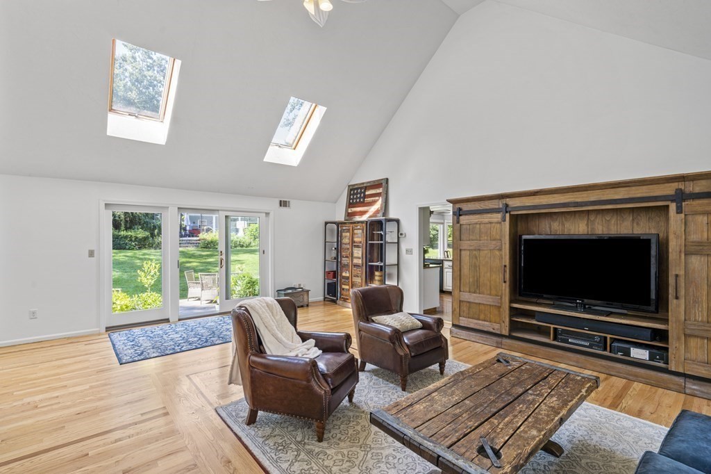 104 Burnt Swamp Road Cumberland, RI 02864 - Photo 12 of 32 a living room with furniture a flat screen tv and a floor to ceiling window