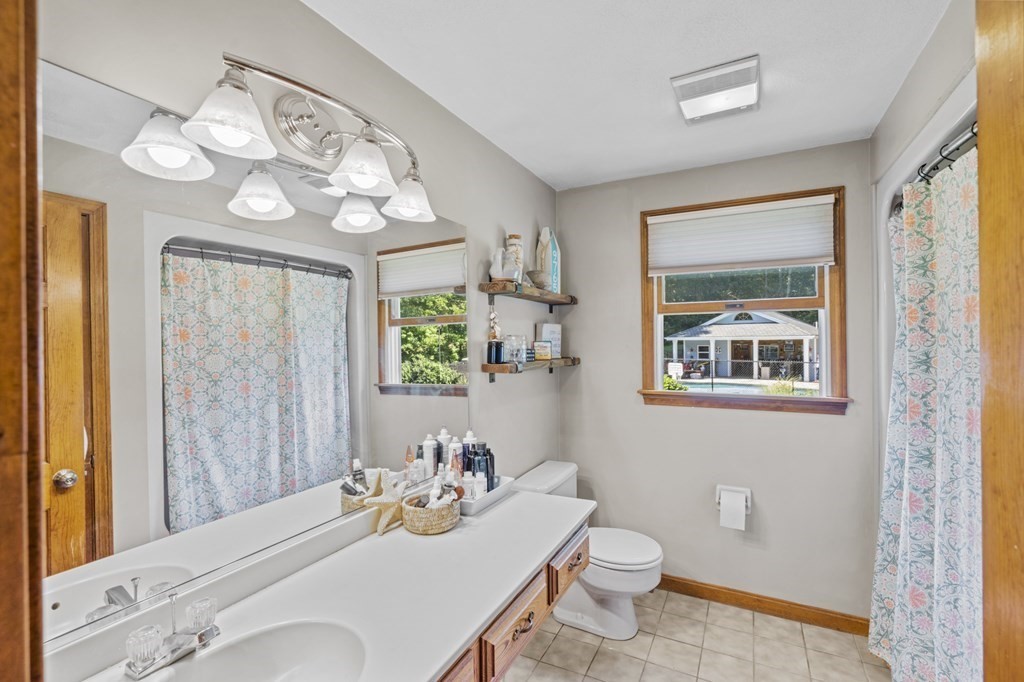 104 Burnt Swamp Road Cumberland, RI 02864 - Photo 20 of 32 a bathroom with a sink a toilet and a mirror