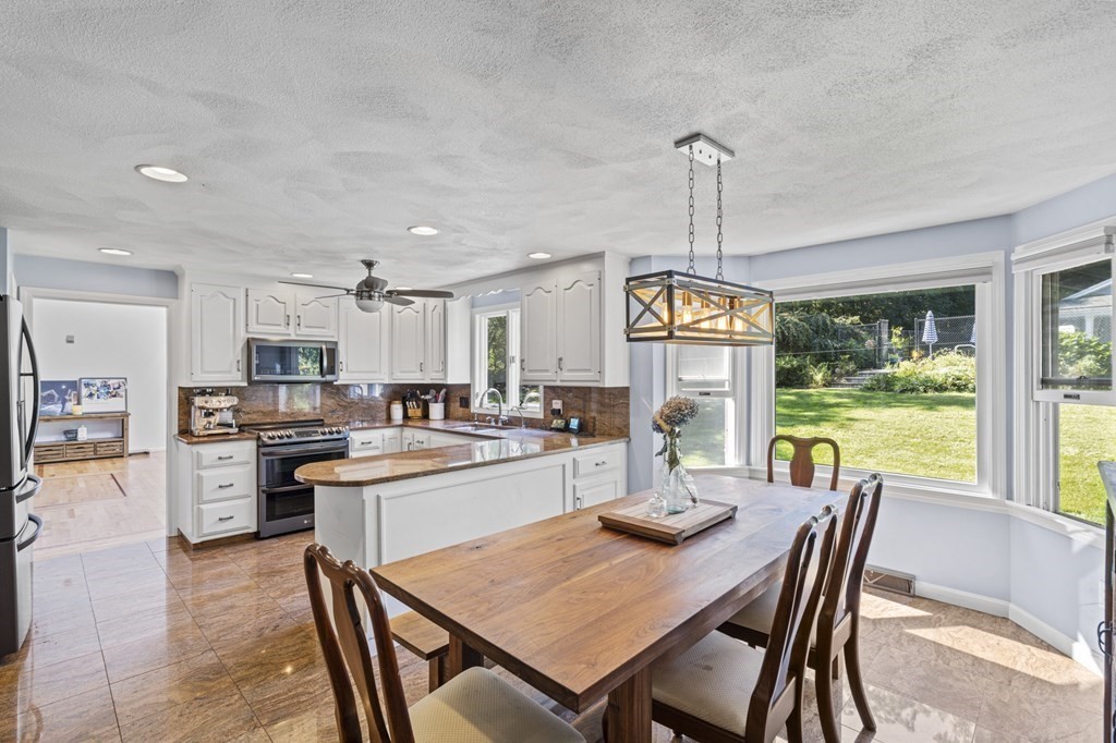 104 Burnt Swamp Road Cumberland, RI 02864 - Photo 8 of 32 a kitchen with stainless steel appliances granite countertop a stove and a dining table with kitchen view