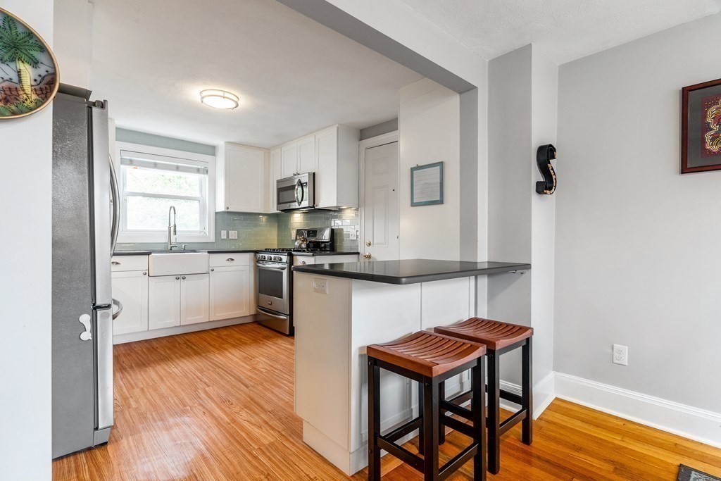 22 Sumner Street Dedham, MA 02026 - Photo 11 of 39 a kitchen with a refrigerator a sink and cabinets
