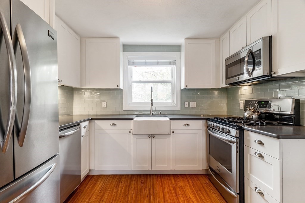 22 Sumner Street Dedham, MA 02026 - Photo 12 of 39 a kitchen with stainless steel appliances granite countertop a stove a sink and a refrigerator