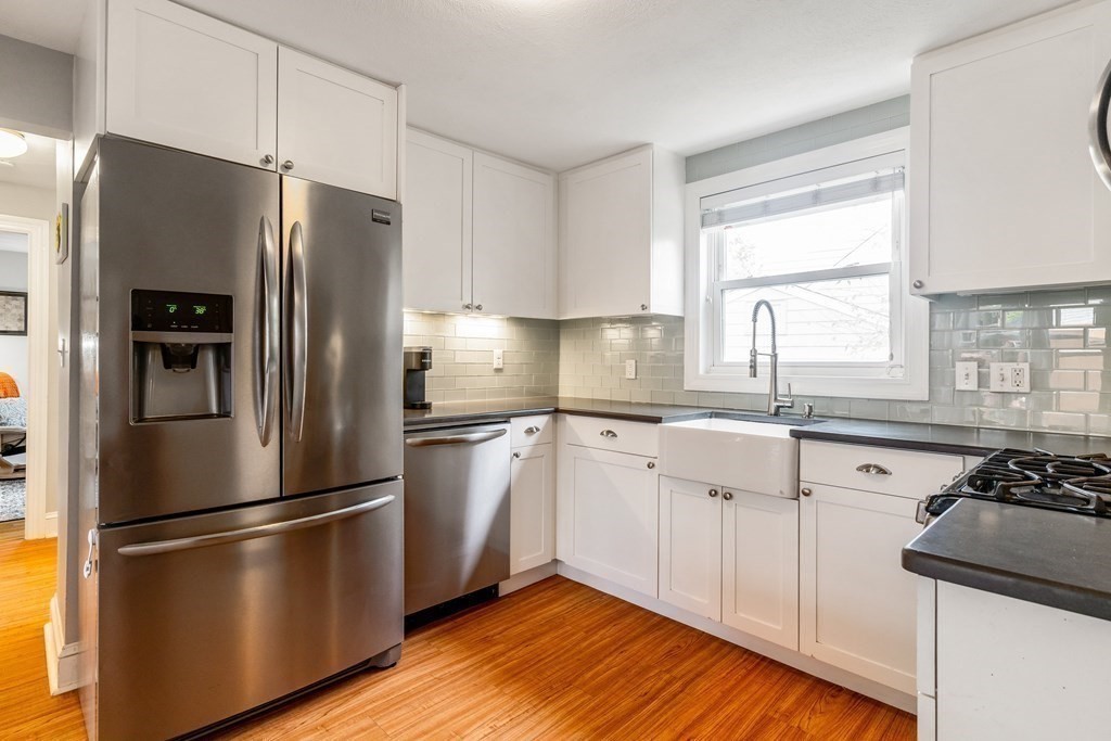 22 Sumner Street Dedham, MA 02026 - Photo 13 of 39 a kitchen with stainless steel appliances a refrigerator sink and wooden floor
