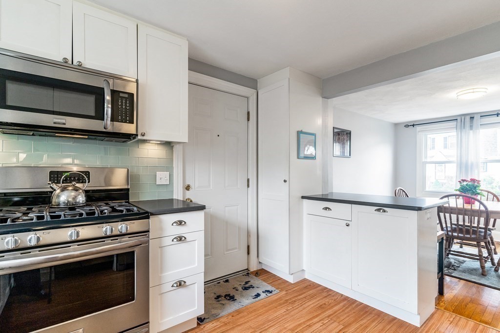 22 Sumner Street Dedham, MA 02026 - Photo 14 of 39 a kitchen with stainless steel appliances white cabinets and stove