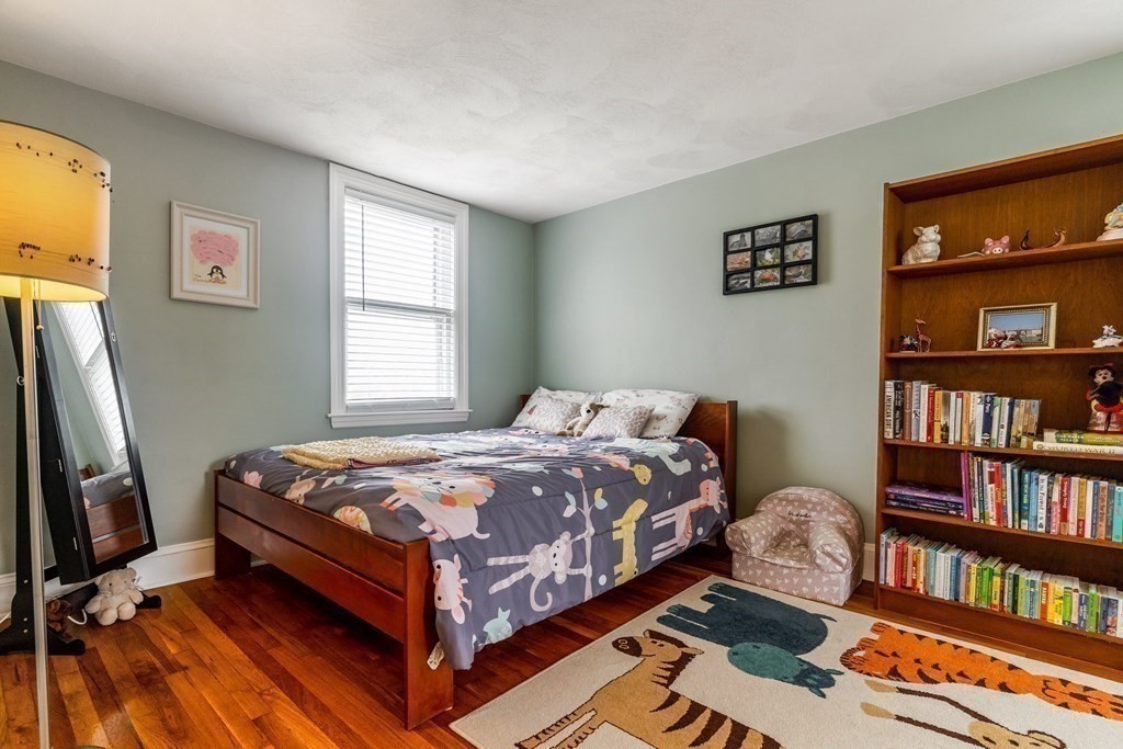 22 Sumner Street Dedham, MA 02026 - Photo 29 of 39 a bed sitting in a bedroom next to a book shelf