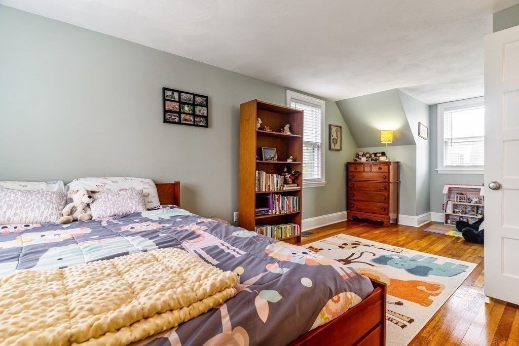 22 Sumner Street Dedham, MA 02026 - Photo 31 of 39 a bedroom with a bed and dresser with mirror