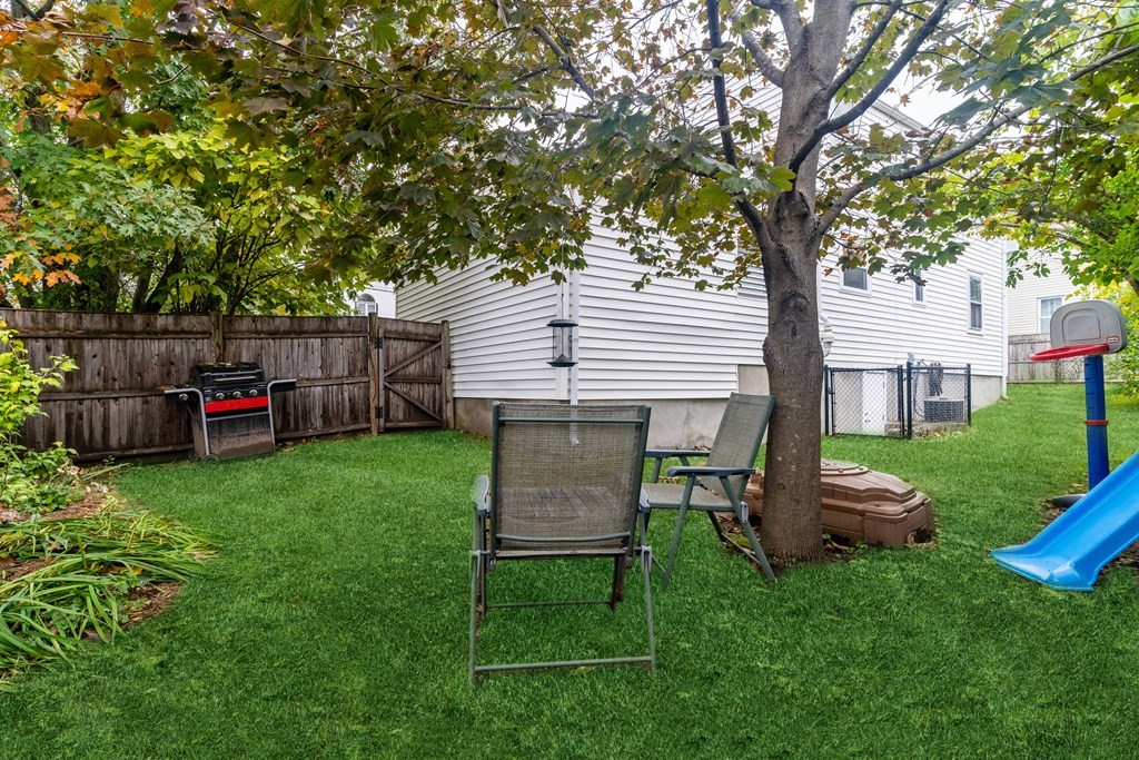 22 Sumner Street Dedham, MA 02026 - Photo 38 of 39 a view of a backyard with table and chairs a fire pit and a large tree