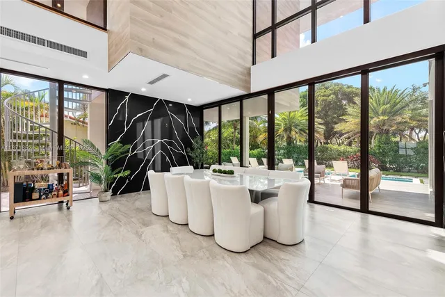 a living room with large windows and a table