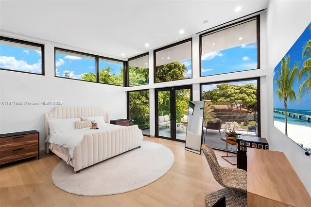 a bedroom with furniture and a large window
