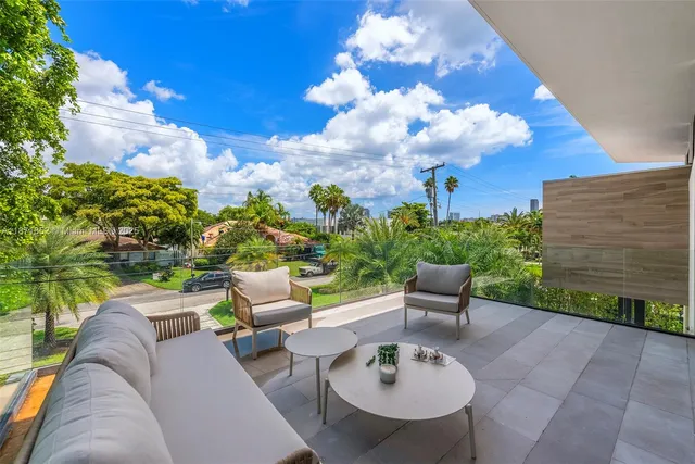 a view of a patio with couches table and chairs and potted plants